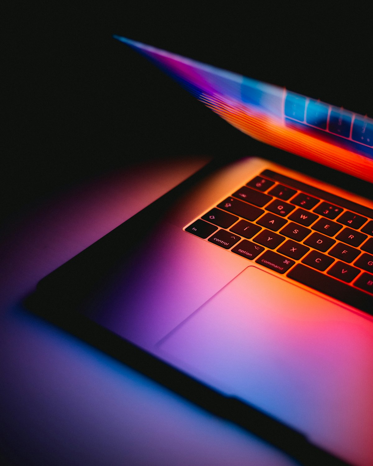 Notebook con una pantalla de colores sobre un escritorio oscuro